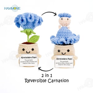 May include: A reversible crochet carnation plant with a blue flower and a fairy doll. The plant is in a beige pot with a happy face and the text "Abracadabra Plant You are both gorgeous like a flower and magical like a fairy" on a white card.