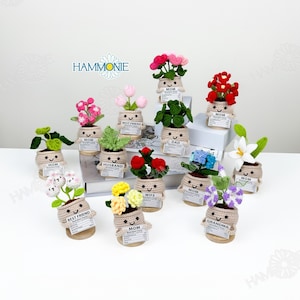May include: A collection of 13 crocheted flower pots with different coloured flowers and personalised labels. The labels include "Mom", "Dad", "Wife", "Husband", "Best Friend", and "Grandma".