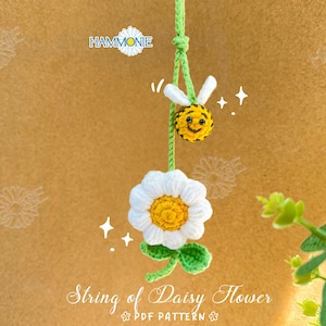 Op de afbeelding: Haakpatroon voor een slinger van madeliefjes met een bij-bedel. Het patroon heet "String of Daisy Flower" en bevat een PDF-patroon.