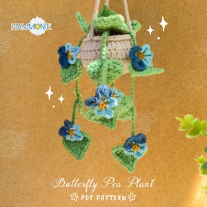 May include: A crocheted butterfly pea plant hanging from a macrame hanger. The plant has green leaves and blue flowers. The text "Butterfly Pea Plant PDF PATTERN" is at the bottom of the image.