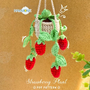 May include: A crocheted strawberry plant hanging from a white pot. The plant has green leaves and red strawberries. The text "Strawberry Plant PDF Pattern" is at the bottom of the image.