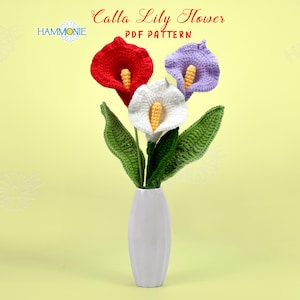 May include: A crocheted bouquet of three Calla Lily flowers in a white vase. The flowers are red, white, and purple. The background is a light yellow.