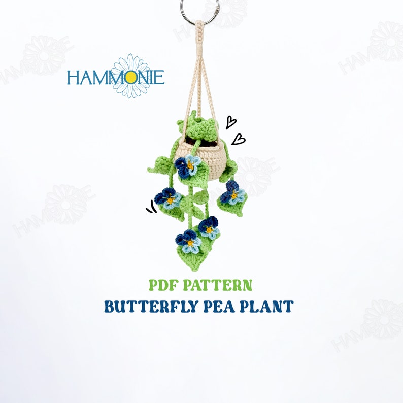 May include: PDF pattern for crocheting a hanging butterfly pea plant. The plant is crocheted in green and blue with a cream-colored pot.