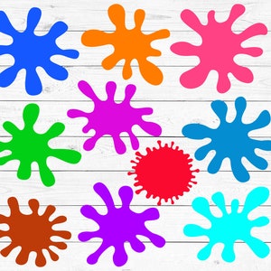 May include: Ten colorful paint splatters in various shades of blue, green, red, orange, purple, and brown. The splatters are arranged in a random pattern on a white wooden background.