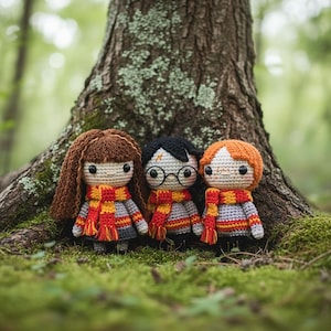 May include: Three handmade crochet dolls featuring yarn hair and matching scarves with red and yellow stripes. The dolls wear grey sweaters and have black button eyes. One doll has long brown hair, one has black hair with a lightning bolt, and one has orange hair.