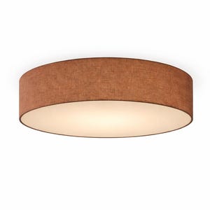 Può includere: Lampada da soffitto rotonda con paralume in tessuto marrone e interno bianco. La luce è accesa, emettendo un bagliore caldo. Il design è semplice e moderno, adatto a varie stanze. Diametro di circa 40 cm.