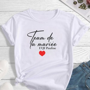 Peut inclure: T-shirt blanc avec un texte noir qui dit "Team de la mariée EVJF Pauline" avec un cœur rouge.