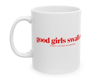 May include: White ceramic mug with the text "good girls swallow" in red, with the phrase "(FIGHT EATING DISORDERS)" below. The mug has a curved handle and a glossy finish. A simple, yet bold design.