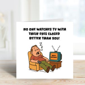 May include: A birthday card featuring a cartoon illustration of a sleeping man in an armchair, holding a remote control, with a television set. The TV displays "Happy Birthday". The card reads, "NO ONE WATCHES TV WITH THEIR EYES CLOSED BETTER THAN YOU!"