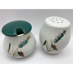May include: A white ceramic sugar bowl with a green lid and a matching salt shaker. Both pieces are decorated with a wheat stalk design in green, brown, and red. The sugar bowl has a handle for a spoon.