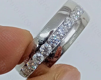 May include: A silver band with a row of clear round stones set in a channel setting.