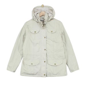 May include: A beige hooded jacket featuring a front zip closure with a snap-button placket, two chest pockets with flaps, and two larger lower pockets with flaps. The interior of the hood is lined with a white fabric featuring a thin red and black grid pattern.