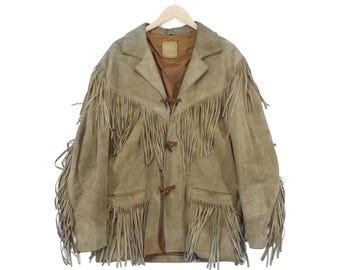 Peut inclure: Une veste en daim beige avec de longues franges sur la poitrine, les manches et les poches inférieures. La veste présente un col à revers, une doublure intérieure marron et trois fermetures à bascule sur le devant pour attacher le vêtement.