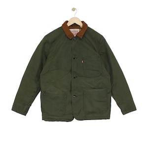 Può includere: Una giacca verde oliva con colletto in velluto a coste marrone, chiusura frontale con bottoni e tre tasche applicate. Una piccola etichetta rossa del marchio Levi Strauss & Co. è visibile sulla tasca pettorale sinistra. Giacca su gruccia.