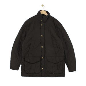 May include: A dark brown quilted jacket featuring a high collar, a front button closure with metallic snaps, and two large patch pockets at the waist. The jacket has a diamond-stitched pattern throughout and is displayed on a wooden hanger.
