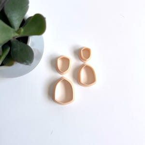 Peut inclure: Trois emporte-pièces en plastique en forme de larme, le plus grand en bas et le plus petit en haut.