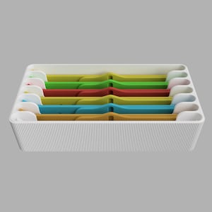 Może przedstawiać: Biały plastikowy organizer z sześcioma przegródkami, z których każda zawiera wkładkę z plastiku w innym kolorze. Wkładki są żółte, niebieskie, pomarańczowe, czerwone, zielone i białe.