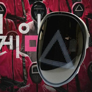 Puede incluir: Una máscara LED negra con un diseño de triángulo blanco. La máscara está delante de un grupo de personas que llevan monos rojos y máscaras negras con diferentes formas.