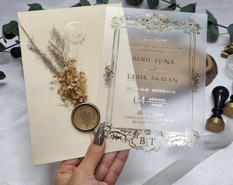 Op de afbeelding: Een gouden en witte huwelijksuitnodiging met een transparante overlay. De uitnodiging heeft een decoratieve rand en de tekst "Durdeven's", "Sizlerle birlikde olmaktan onur duyariz", "Beril Tuna", "ve", "Tarik Akman", "Nikah: 18.00", "Dugun: 19.00", "04 Agustos Pazar", "Mio Sou dino", "Cumhuriyet Beykoz 11, No.70", "Beykoz Istanbul", en "BT".