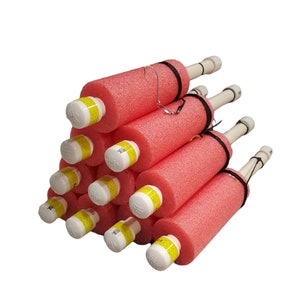 May include: A stack of pink foam pool noodles with yellow and white caps. The noodles are tied together with black string and have a metal hook attached to the top.