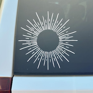 May include: A white ceramic mug with a black handle and the text "But First, Coffee" in a handwritten style. The mug is on a white surface. The mug is approximately 4 inches tall.