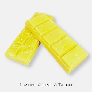 Peut inclure: Deux barres de cire parfumée rectangulaires jaunes avec un motif en grille segmenté. La surface de la cire est jaune vif avec des taches blanches dispersées. Le texte LIMONE & LINO & TALCO est imprimé en noir au bas de l'image.