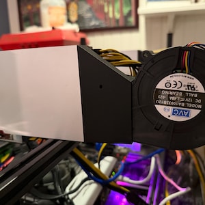May include: A black blower fan with a white label reading AVC MODEL BA10033B12U DC 12V 2.40A BALL BEARING attached to a white rectangular housing. The fan features multi-colored wires including yellow, blue, and red, and is mounted on a black frame.