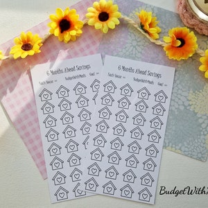 Puede incluir: Dos hojas imprimibles de pegatinas con un diseño de casa y corazón. Las hojas se titulan "6 Months Ahead Savings" e incluyen el texto "Each House = BudgetWithMads Goal = ".