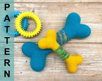 Puede incluir: Dos juguetes para perros en forma de hueso de crochet, uno amarillo y otro azul, con un juguete de anillo texturizado amarillo y azul en el fondo.