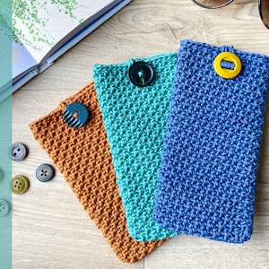 May include: Three crocheted eyeglass cases in different colors: brown, teal, and blue. Each case has a button closure.