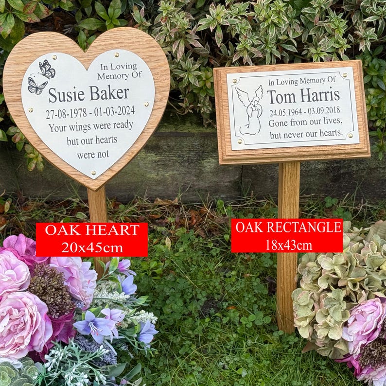 May include: Two wooden memorial plaques on stakes. One is heart-shaped, the other rectangular. The heart plaque is 20cm x 45cm, and the rectangle plaque is 18cm x 43cm. Both plaques have memorial text, including names and dates, and are set in a garden.