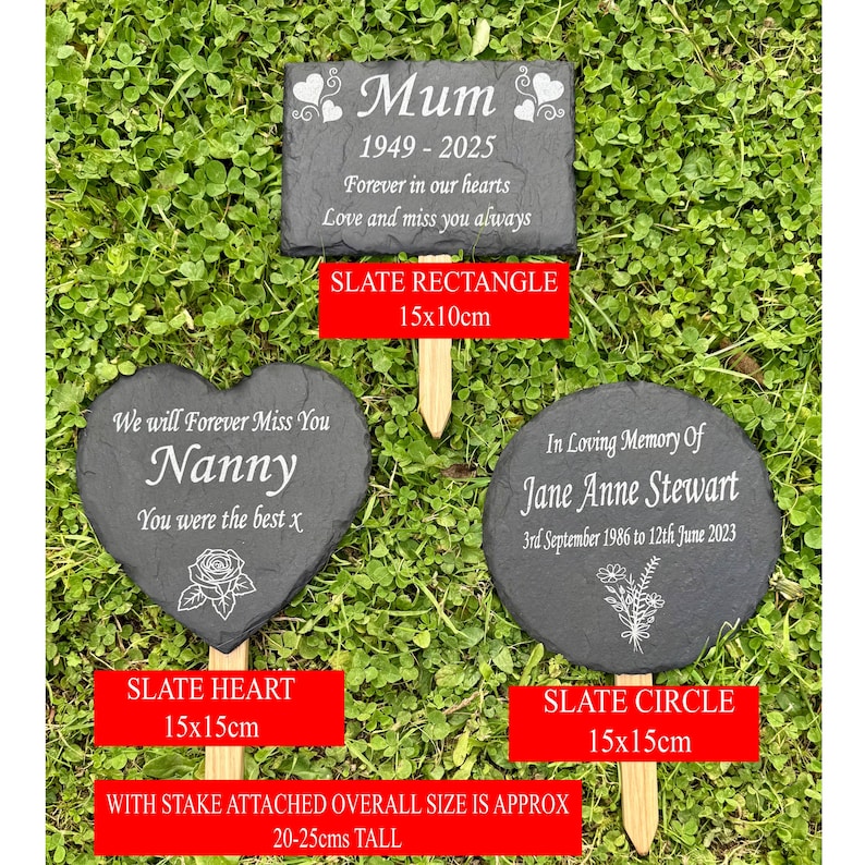 May include: Three slate memorial garden markers with wooden stakes. The markers are in rectangle, heart, and circle shapes. The rectangle reads "Mum 1949-2025". The heart says "Nanny". The circle says "In Loving Memory of Jane Anne Stewart".