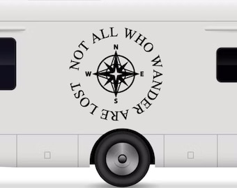 Peut inclure: Un camping-car blanc avec un autocollant noir sur le côté qui dit "Not all who wander are lost" avec une rose des vents au centre.