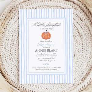 Può includere: Invito per baby shower con sfondo a righe blu e bianche. L'invito include il testo "A little pumpkin is on the way" e i dettagli per il baby shower di Annie Blake, tra cui data, ora e luogo.