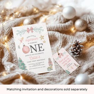 May include: A pink and green first birthday invitation with a pink ornament, a fairy, and a nutcracker. The invitation says "Our little sugarplum is turning one" and "Join us to celebrate Callie's Fairy First Birthday". A matching thank you tag says "Thank you for making my party sweet".