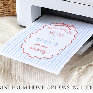 Peut inclure: Une feuille de papier &agrave; rayures bleues et blanches est imprim&eacute;e &agrave; partir d'une imprimante blanche. Le papier a une bordure d&eacute;corative rouge avec les mots "Welcome to Sadie's second birthday" en texte rouge et bleu.