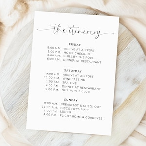 Könnte beinhalten: Eine weiße Reiseroute-Karte mit schwarzem Text, die Aktivitäten für Freitag, Samstag und Sonntag auflistet. Der Titel "the itinerary" ist in einer kursiven Schriftart gehalten. Zu den Aktivitäten gehören Ankunft am Flughafen, Check-in im Hotel, Weinprobe und Abendessen.