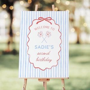 Peut inclure: Panneau de bienvenue sur chevalet avec fond &agrave; rayures bleues et blanches. Le panneau a une bordure festonn&eacute;e rouge et comporte le texte "WELCOME TO SADIE'S second birthday" en script rouge et bleu.