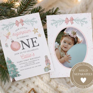 May include: A two-sided birthday invitation card featuring a pink ornament, a Christmas tree, a nutcracker, and a ballerina illustration. The text reads Our little sugarplum is turning ONE. The second side features an oval photo frame for a child.