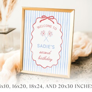 Peut inclure: Un panneau encadr&eacute; avec une bordure dor&eacute;e. Le panneau a un fond &agrave; rayures bleues et blanches et une bordure rouge festonn&eacute;e. Le texte indique "Bienvenue au deuxi&egrave;me anniversaire de Sadie" avec des feux d'artifice crois&eacute;s. Disponible en 20.3x25.4cm, 40.6x50.8cm, 45.7x61cm, et 50.8x76.2cm.