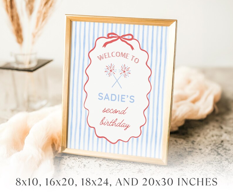 Peut inclure: Un panneau encadr&eacute; avec une bordure dor&eacute;e. Le panneau a un fond &agrave; rayures bleues et blanches et une bordure rouge festonn&eacute;e. Le texte indique "Bienvenue au deuxi&egrave;me anniversaire de Sadie" avec des feux d'artifice crois&eacute;s. Disponible en 20.3x25.4cm, 40.6x50.8cm, 45.7x61cm, et 50.8x76.2cm.