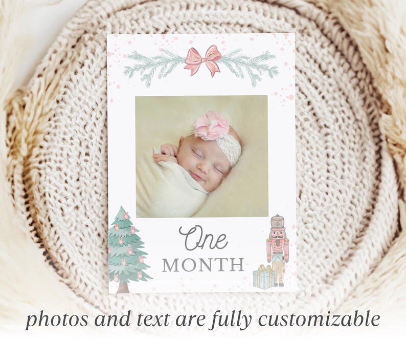May include: A rectangular milestone card featuring a central photo of a baby wearing a pink flower headband. The card is decorated with a pink bow, pine branches, a Christmas tree, a nutcracker, and the text One MONTH in gray lettering.