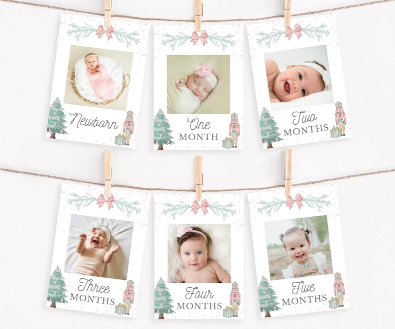 May include: Six rectangular milestone cards hanging on twine with wooden clips. Each card features a baby photo, a pink bow, a Christmas tree, a nutcracker, and text indicating age from Newborn to Five Months in a script and block font style.