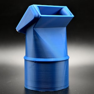 May include: A vibrant blue, 3D-printed object with a unique geometric design. It features a cylindrical base, a central section with angled facets, and a rectangular opening at the top. The object is made of plastic.