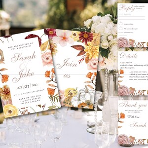 Op de afbeelding: Herfstbruiloft uitnodigingsset met bloemmotieven in tinten oranje, geel en roze. De uitnodigingen tonen de namen "Sarah & Jake" en de datum "Oct 03, 2022".