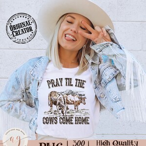 May include: A white t-shirt with a brown and white illustration of two cows and the text "Pray Til The Cows Come Home".