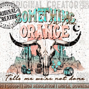 May include: A digital design featuring a cow skull with long horns, set against a desert landscape with cacti and mountains. The text "Something in the Orange" is displayed in turquoise and peach colors, with the phrase "Tells me we're not done" below.