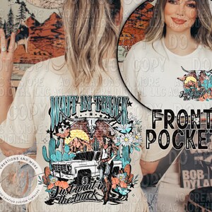 Peut inclure: Un t-shirt beige avec un motif graphique repr&eacute;sentant un camion, un cactus et un coucher de soleil. Le texte "Wait in Truck" et "Just wait in the truck" sont sur le t-shirt. Le t-shirt a une poche sur le devant avec une version plus petite du motif graphique.