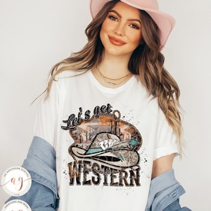 K&ouml;nnte beinhalten: Ein wei&szlig;es T-Shirt mit einem Grafikdesign eines Cowboyhuts mit Spielkarten und dem Text "Let's get Western".