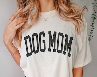 May include: A white t-shirt with the text "DOG MOM" printed in black.
